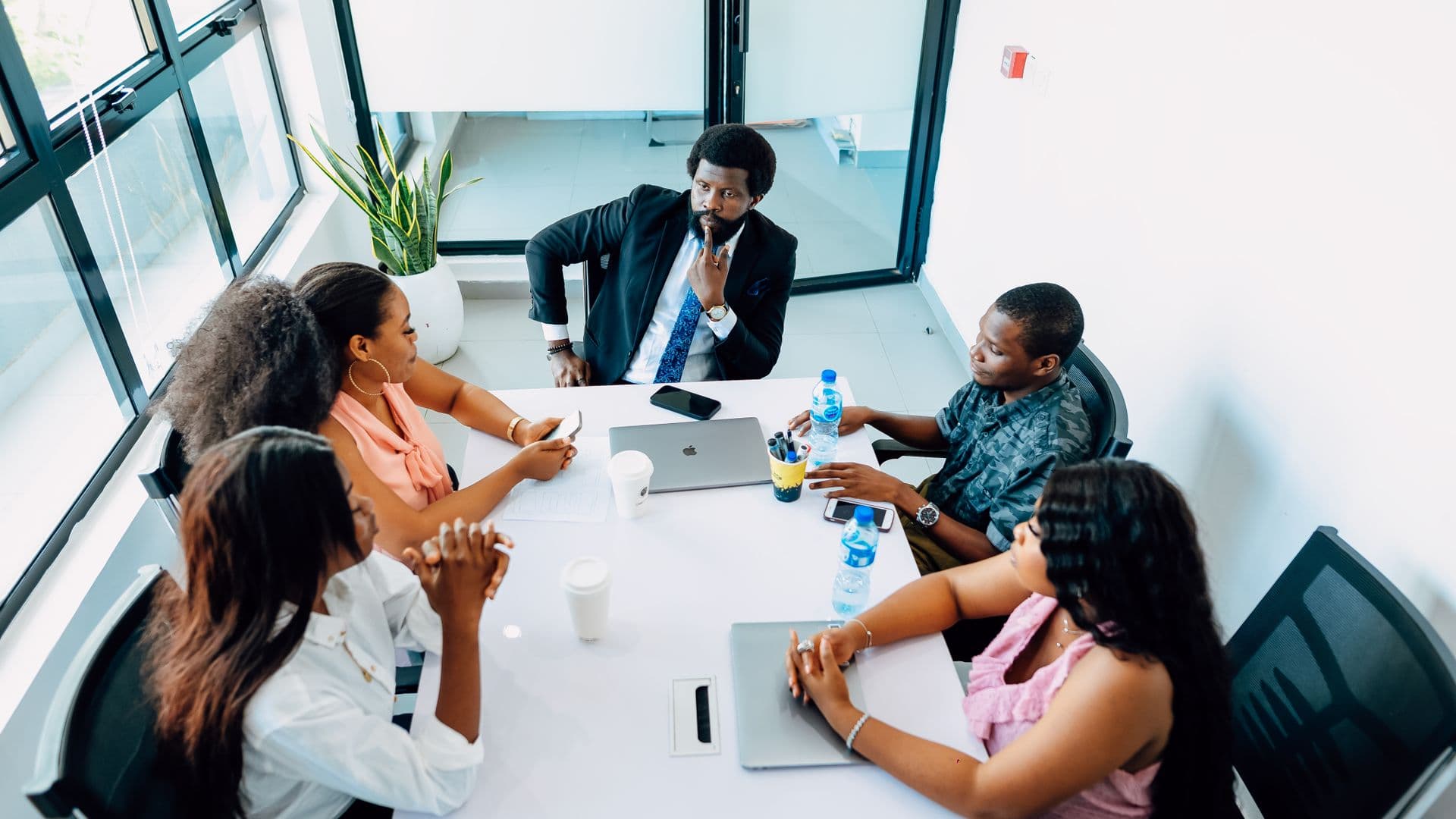 Une équipe dirigeante en réunion dans un bureau lumineux d'Afrique de l'Ouest.